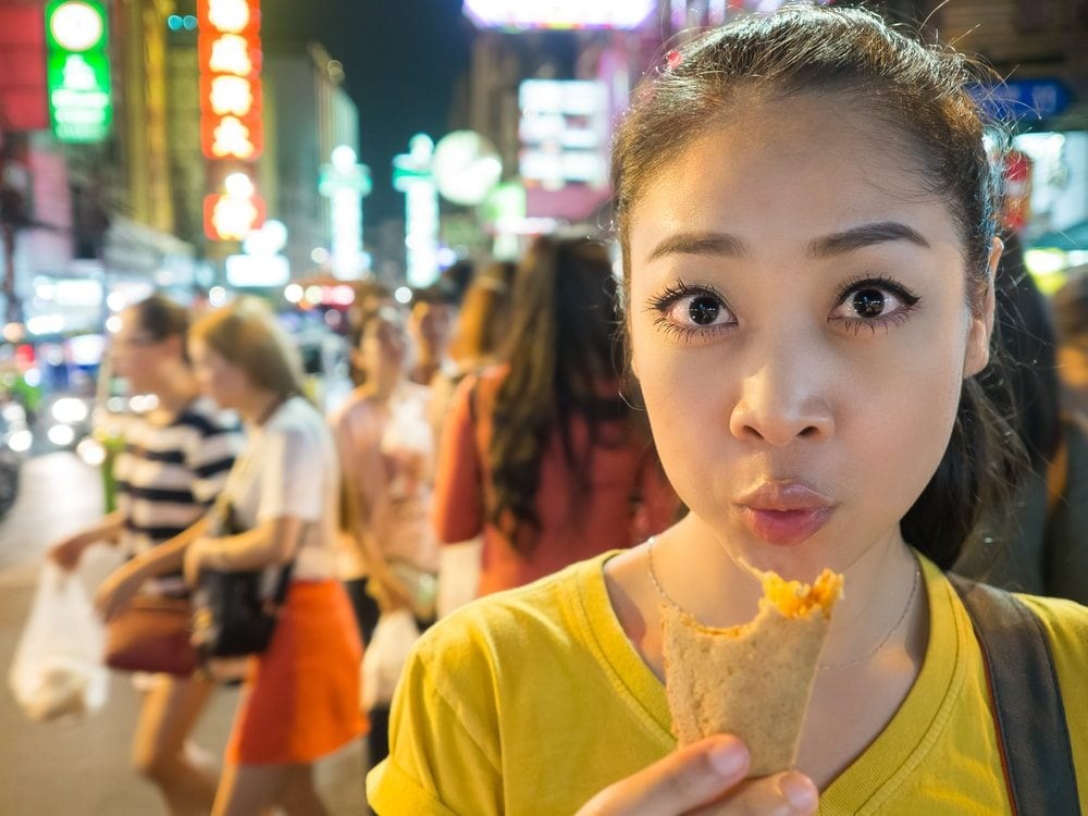Dívka ochutnávající street food