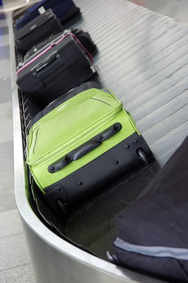 zavazadlový pás se zeleným kufrem