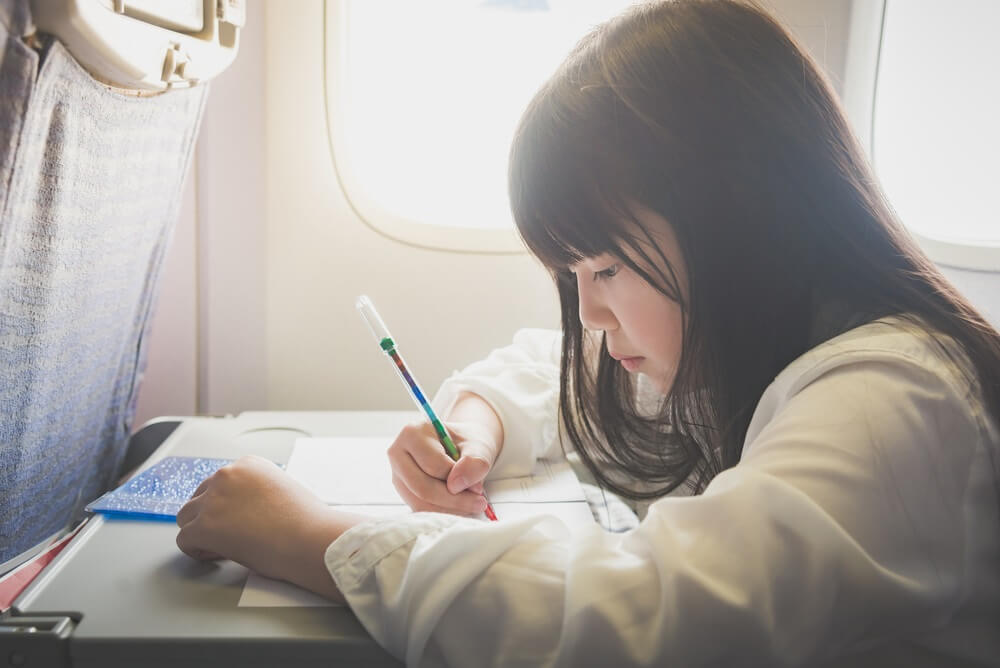 Malé děvče si kreslí během letu