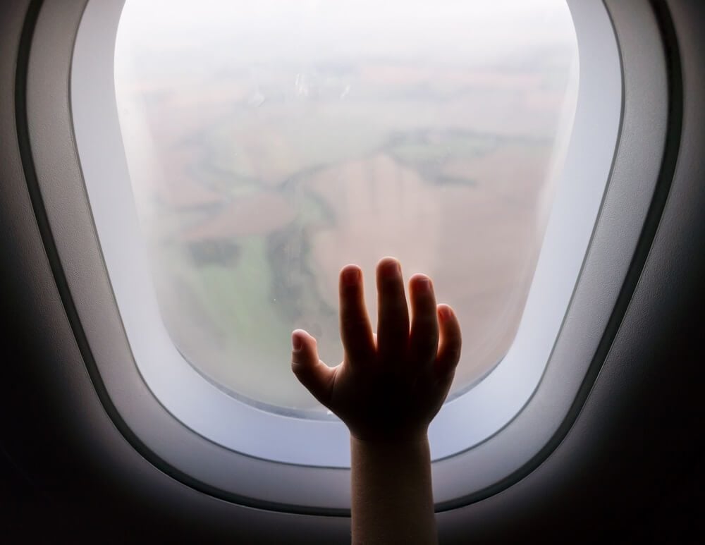 Dětská ruka na okénku letadla