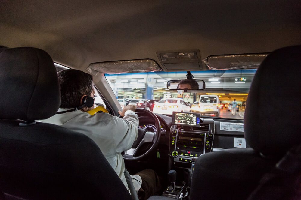 Řidič taxi služby v Dubaji.