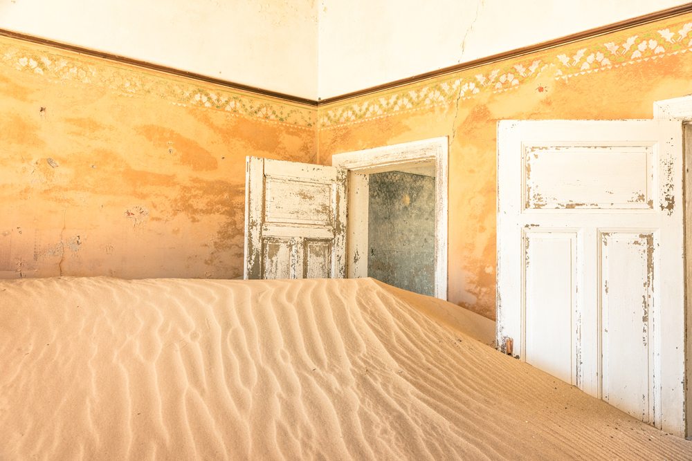 Opustěný dům zasypaný pískem v Namibii.