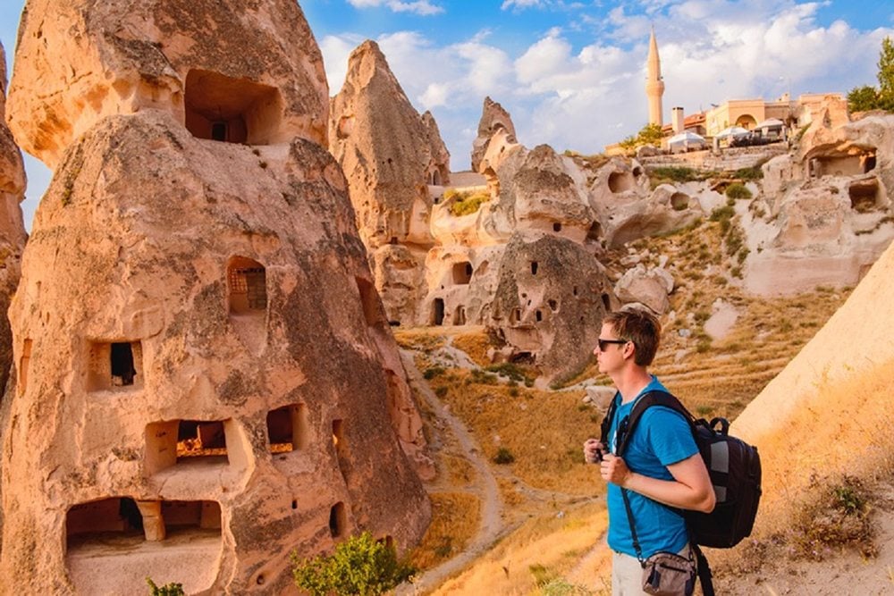 Turista u památek v regionu Cappadocia.