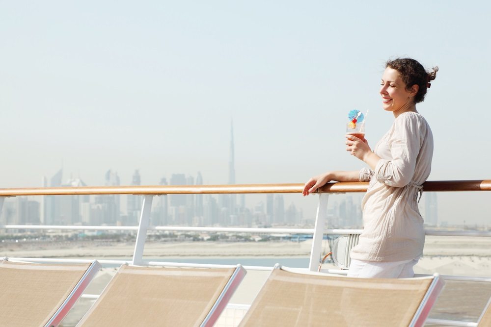 Žena na lodi s drinkem v ruce.