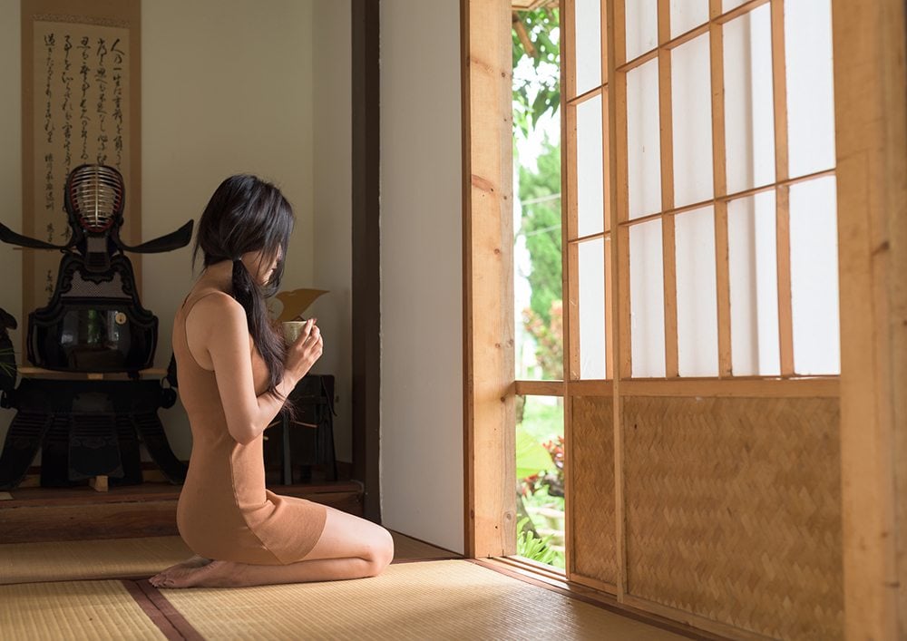 Žena sedící na japonské podlaze tatami.